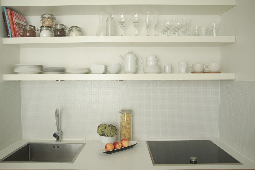 Minimal white kitchen with open shelves and a single sink