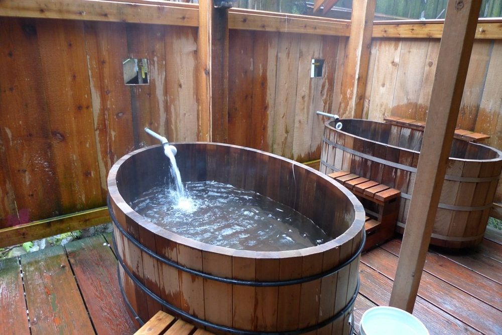 Deep wooden soaking tubs in a timber-walled bathing room