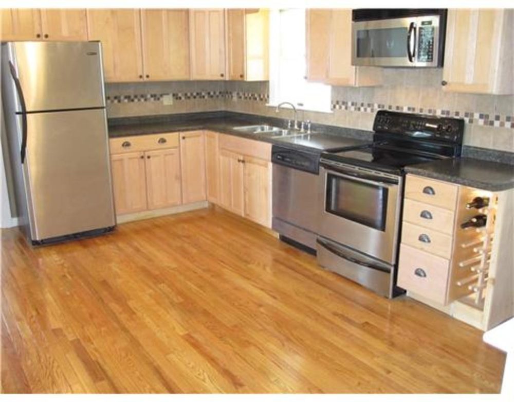 Bright kitchen with warm hardwood flooring and light wood cabinets