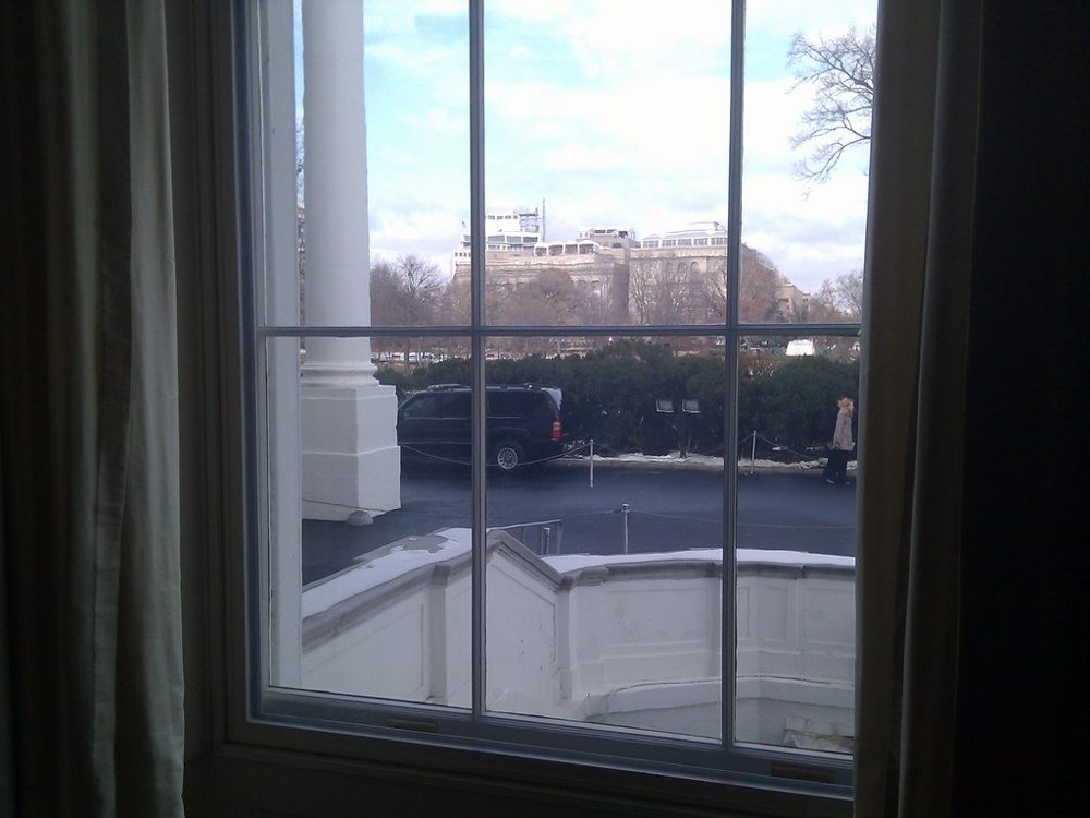 Tall multi-pane window looking out onto a bright courtyard